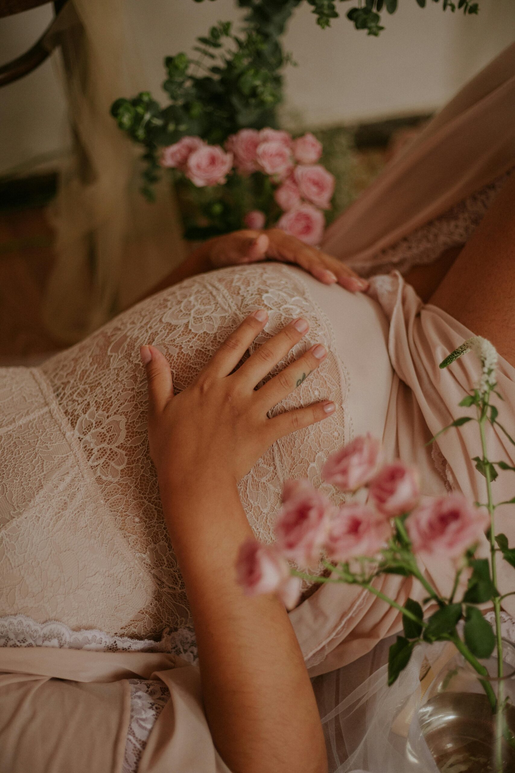 ventre de femme enceinte avec des fleurs roses